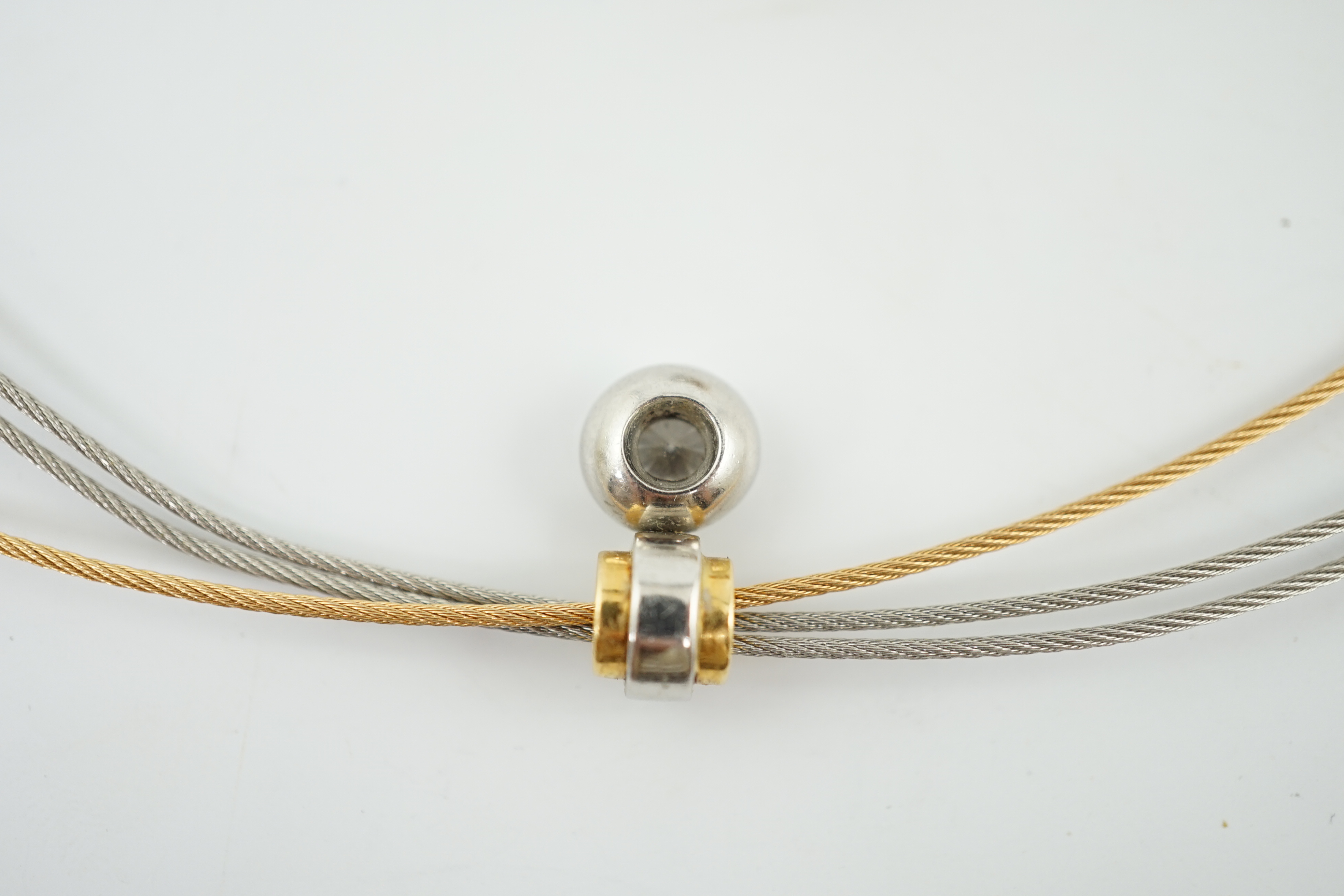 A modern platinum and 18k gold triple strand necklet, with round and princess cut diamond set pendant and a pair of matching earrings